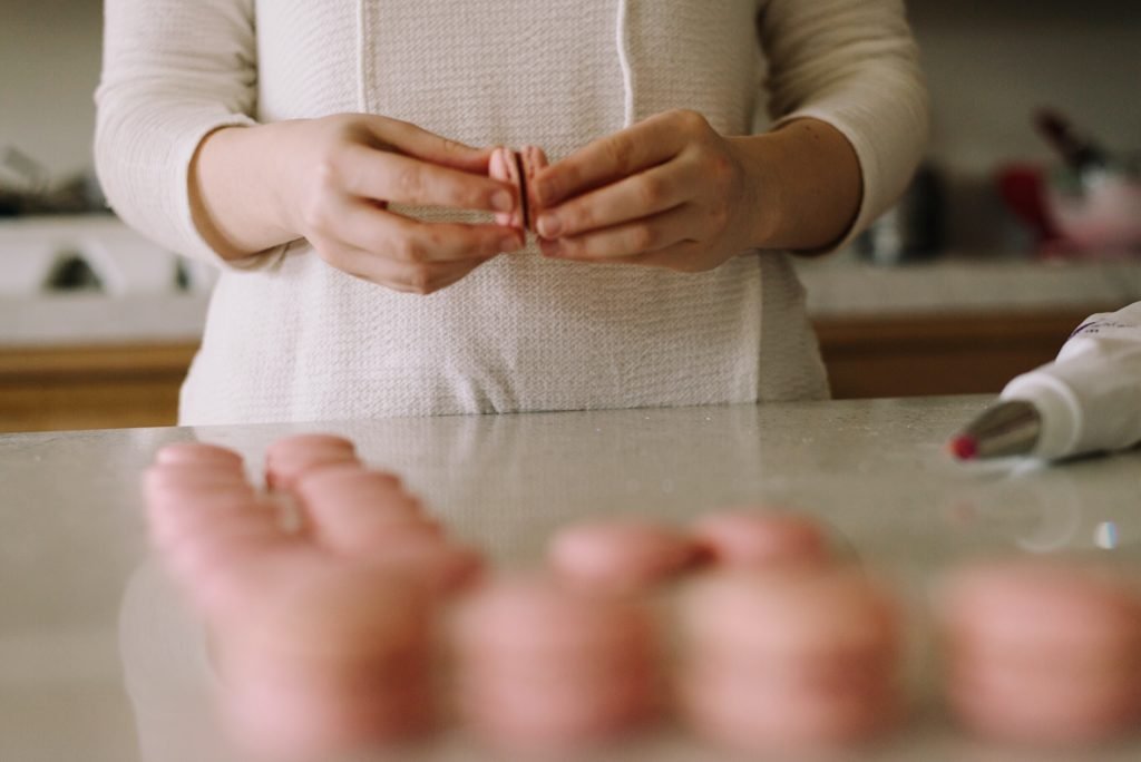 Une ouvrière monte des macarons