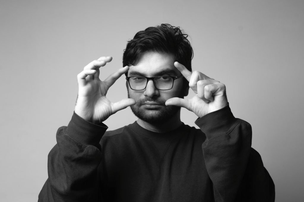 Un homme avec des lunettes forme un cadre avec ses mains
